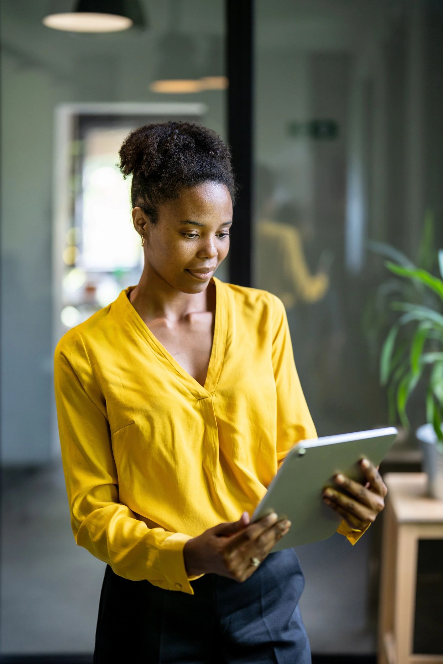 Manager africaine utilisant une tablette dans un environnement premium